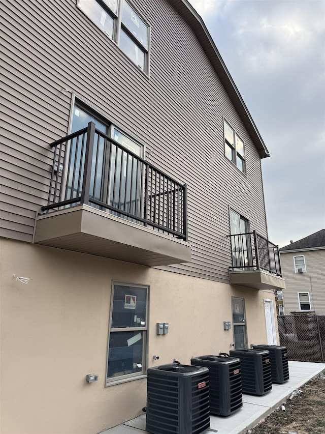 view of property exterior with a balcony and central AC unit