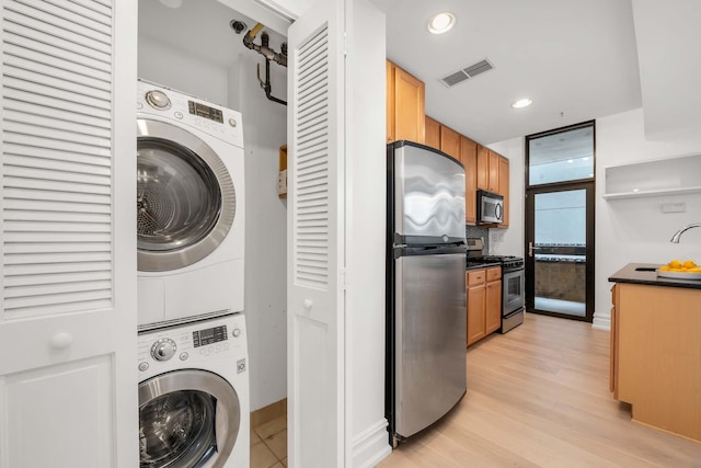 610 Newark St Unit 4A, Hoboken, NJ 07030 - washroom featuring stacked washing machine and dryer, light wood-style flooring, recessed lighting, and baseboards