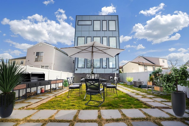 rear view of property featuring central AC, fence, and a lawn