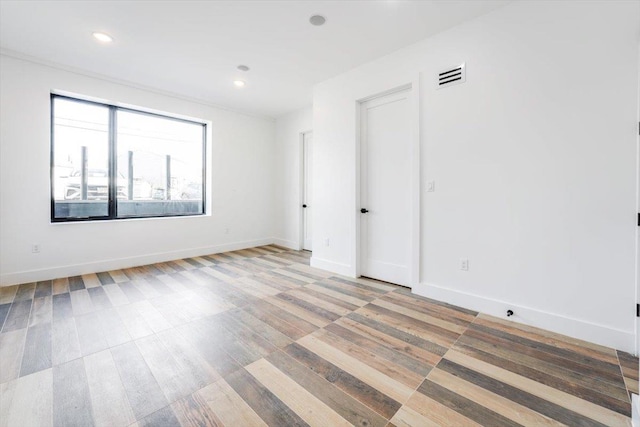 empty room with baseboards, visible vents, and recessed lighting