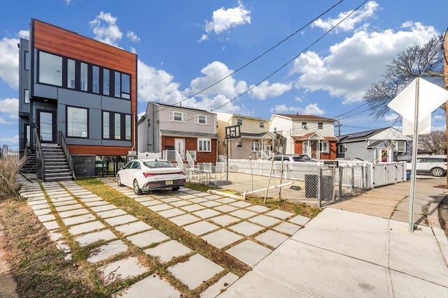 exterior space with stairs, a gate, fence, and a residential view