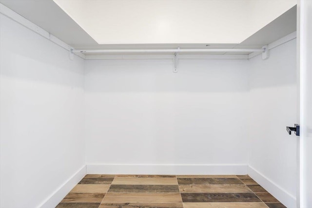 walk in closet with dark wood-type flooring