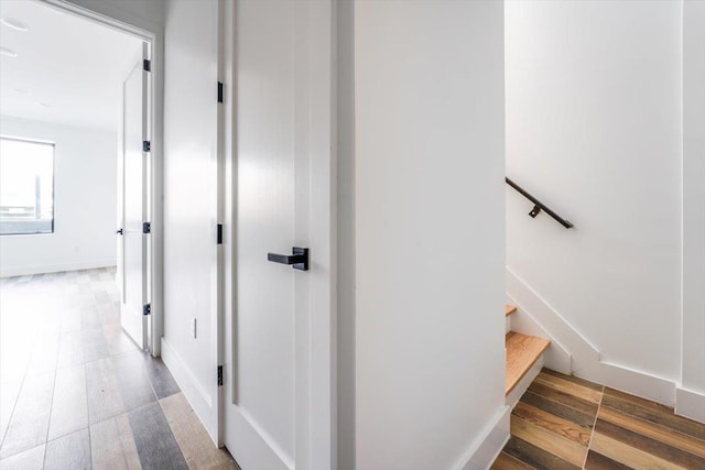 staircase featuring wood-type flooring and baseboards