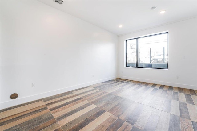 empty room with recessed lighting, visible vents, and baseboards