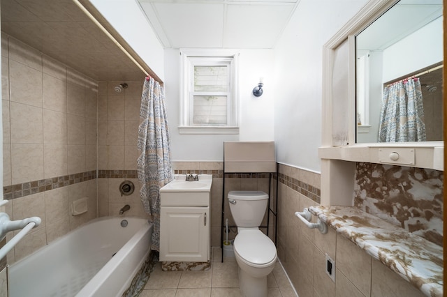 full bathroom with tile patterned floors, toilet, shower / tub combo, tile walls, and vanity