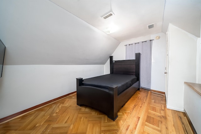 bedroom with light parquet flooring and lofted ceiling