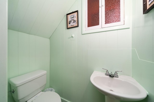 bathroom with lofted ceiling, sink, and toilet