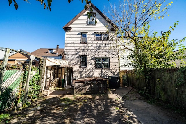 back of house with central AC unit