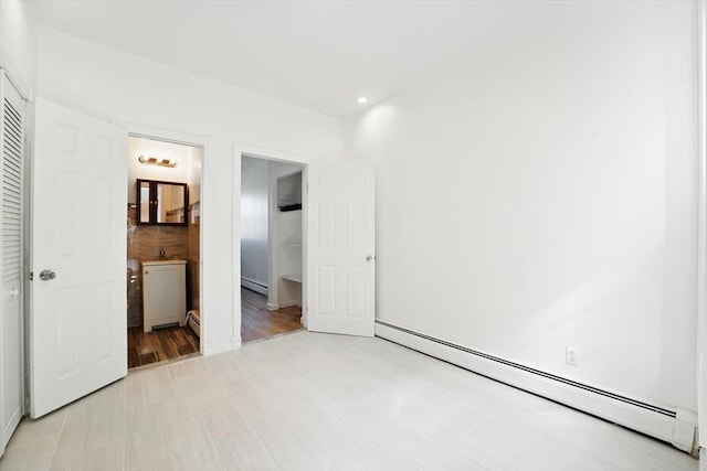 138 Leonard St Unit 2R, Jersey City, NJ 07307 - unfurnished bedroom with a baseboard heating unit, connected bathroom, and a closet