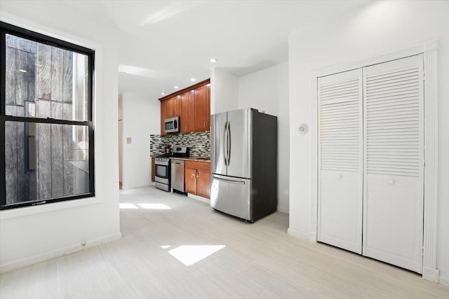138 Leonard St Unit 2R, Jersey City, NJ 07307 - kitchen with stainless steel appliances, decorative backsplash, brown cabinetry, baseboards, and recessed lighting
