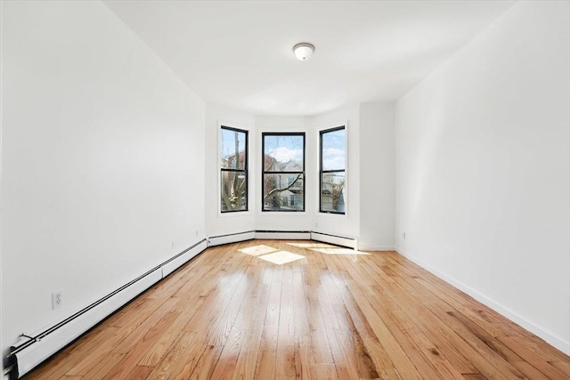 138 Leonard St Unit 2R, Jersey City, NJ 07307 - empty room with a baseboard heating unit, hardwood / wood-style floors, and baseboards