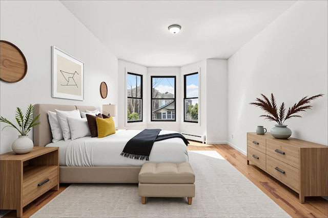 138 Leonard St Unit 2R, Jersey City, NJ 07307 - bedroom featuring a baseboard radiator, light wood-style floors, and baseboards