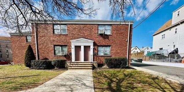 colonial house with brick siding and a front lawn