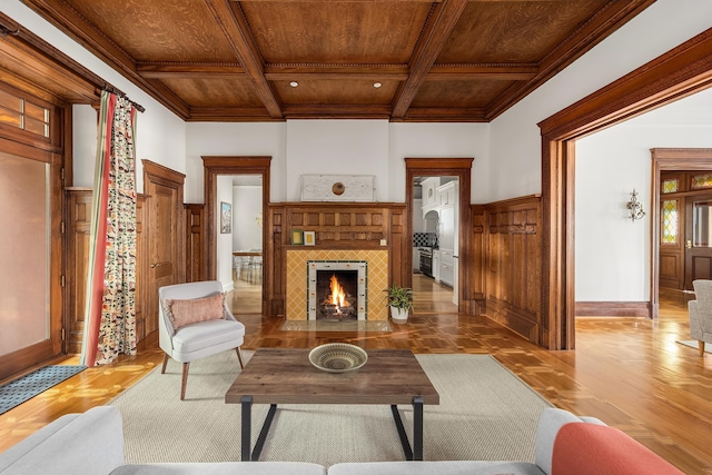 living room featuring wooden ceiling, hardwood / wood-style flooring, beamed ceiling, crown molding, and a tile fireplace