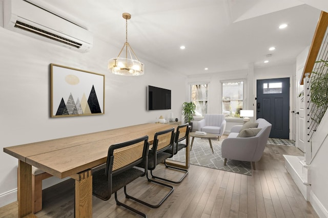 dining room featuring hardwood / wood-style floors and a wall unit AC