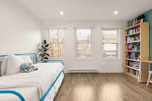 bedroom with a baseboard radiator and light wood-type flooring