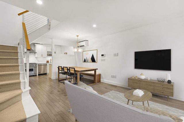 living room featuring light hardwood / wood-style floors and a wall mounted air conditioner