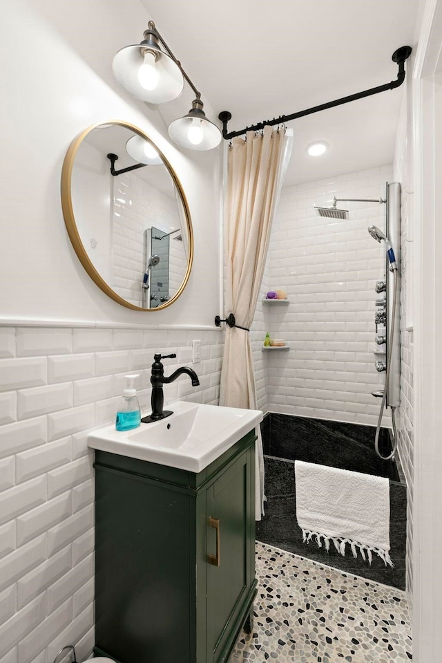 bathroom with a shower with shower curtain, vanity, tile walls, and tile patterned floors