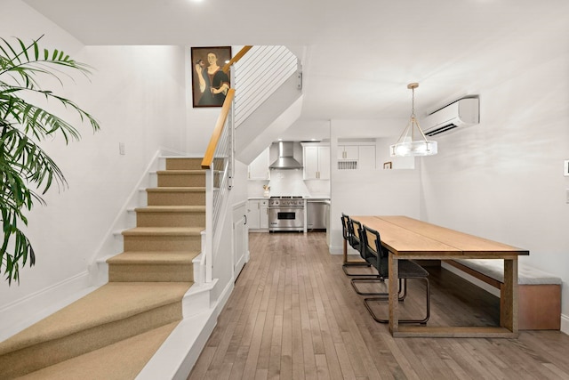 dining area featuring a wall mounted AC and hardwood / wood-style floors