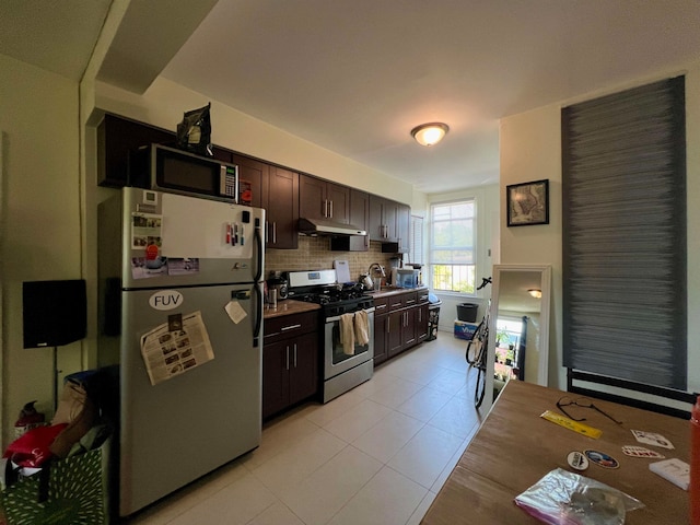 kitchen with stainless steel appliances, dark brown cabinetry, sink, tasteful backsplash, and light tile patterned floors