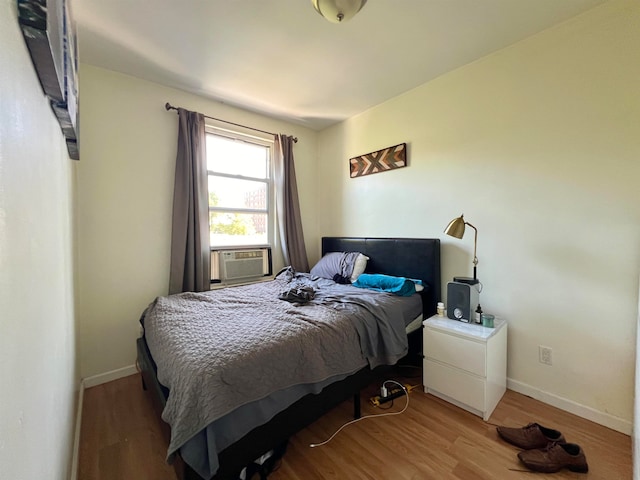 bedroom featuring hardwood / wood-style floors and cooling unit