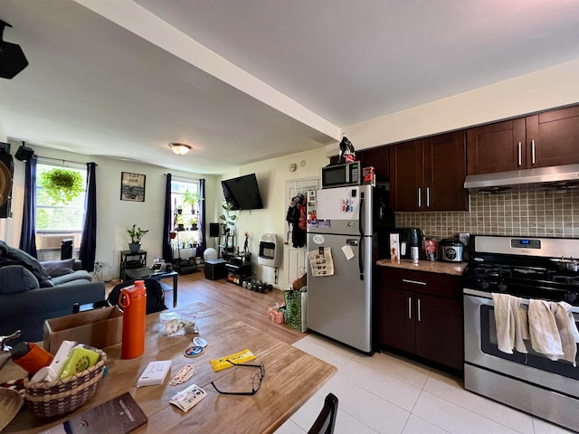 kitchen featuring backsplash, dark brown cabinetry, light tile patterned floors, and stainless steel appliances