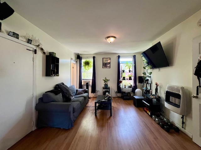 living room with heating unit and hardwood / wood-style flooring