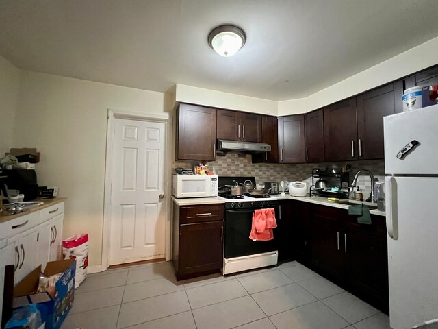 kitchen with decorative backsplash, dark brown cabinetry, sink, light tile patterned flooring, and white appliances