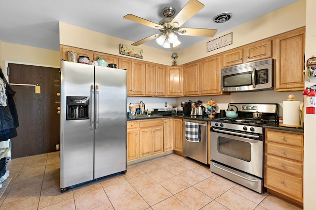 kitchen featuring dark countertops, visible vents, appliances with stainless steel finishes, and a sink