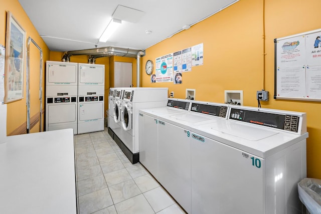 shared laundry area featuring light tile patterned floors, separate washer and dryer, and stacked washer and clothes dryer