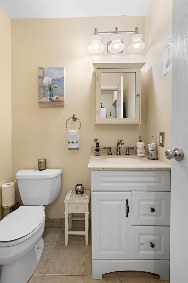 bathroom with tile patterned flooring, toilet, vanity, and baseboards