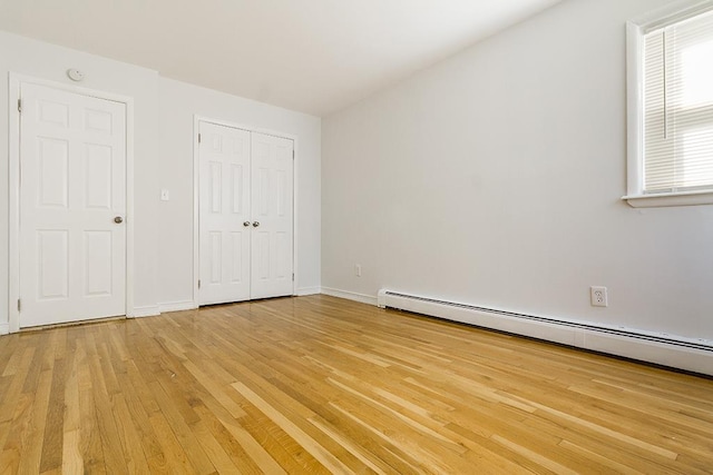 226 57th St, West New York, NJ 07093 - unfurnished bedroom featuring a baseboard heating unit, light wood-style flooring, and a closet