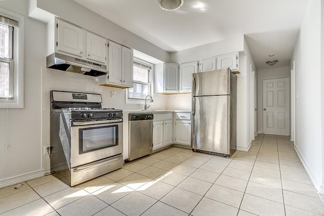 226 57th St, West New York, NJ 07093 - kitchen with appliances with stainless steel finishes, under cabinet range hood, light tile patterned floors, white cabinets, and light countertops