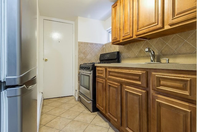 226 57th St, West New York, NJ 07093 - kitchen with appliances with stainless steel finishes, light tile patterned floors, brown cabinets, tasteful backsplash, and light countertops