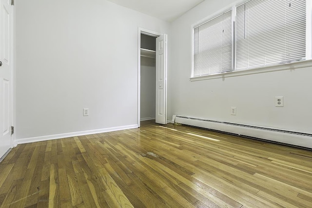 226 57th St, West New York, NJ 07093 - unfurnished bedroom with wood-type flooring, a baseboard radiator, and a closet