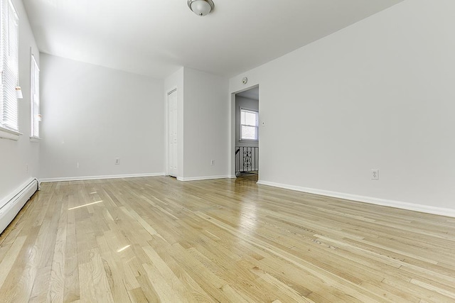 226 57th St, West New York, NJ 07093 - empty room with light wood-style floors and a baseboard radiator