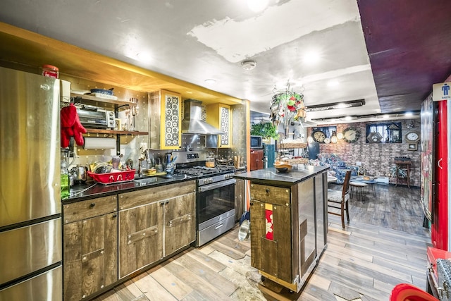 209 48th St Unit A, Union City, NJ 07087 - kitchen featuring appliances with stainless steel finishes, wall chimney exhaust hood, dark countertops, light wood-style floors, and a kitchen island