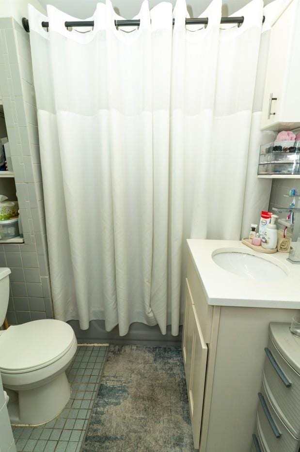 704 90th St, North Bergen, NJ 07047 - bathroom with tile patterned flooring, toilet, vanity, and shower / tub combo with curtain
