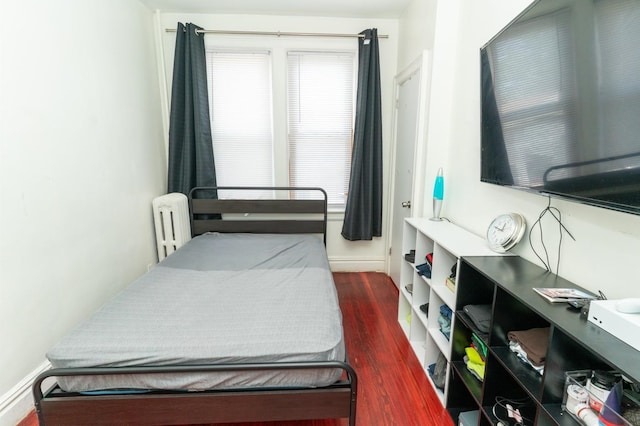 704 90th St, North Bergen, NJ 07047 - bedroom with wood finished floors, radiator, and baseboards