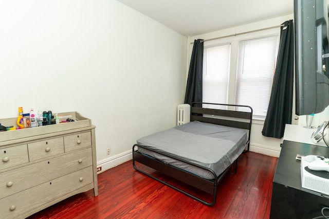 704 90th St, North Bergen, NJ 07047 - bedroom with radiator heating unit, dark wood-type flooring, and baseboards