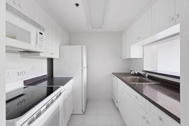 1 2nd St Unit 314, Jersey City, NJ 07302 - kitchen with white appliances, a sink, dark countertops, white cabinetry, and light tile patterned flooring