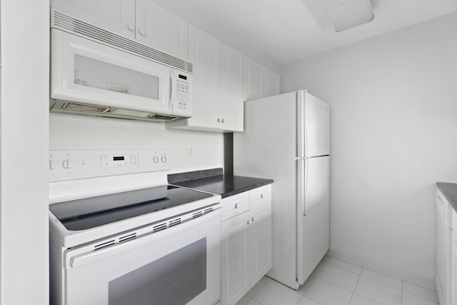 1 2nd St Unit 314, Jersey City, NJ 07302 - kitchen featuring white appliances, white cabinets, baseboards, and dark countertops