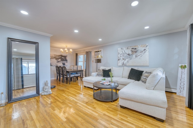 living room featuring a chandelier, light wood-type flooring, ornamental molding, and a baseboard radiator