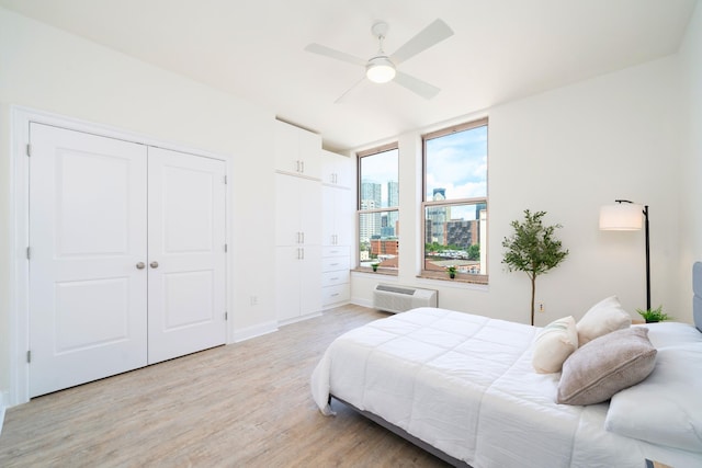 10 Regent St Unit 807, Jersey City, NJ 07302 - bedroom featuring light wood-style flooring, a wall mounted air conditioner, a ceiling fan, and a view of city