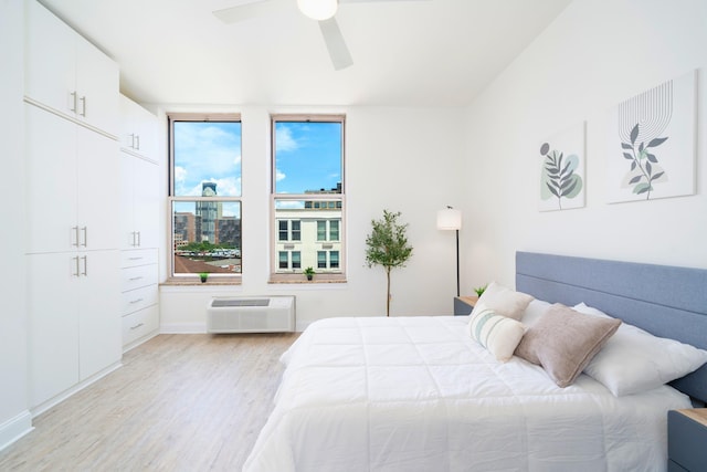 10 Regent St Unit 807, Jersey City, NJ 07302 - bedroom with an AC wall unit, light wood-style flooring, and a ceiling fan
