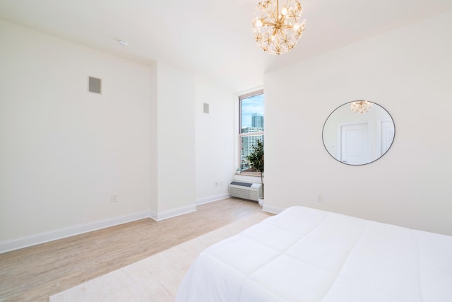 10 Regent St Unit 807, Jersey City, NJ 07302 - bedroom with a chandelier, light wood-type flooring, and a wall mounted air conditioner