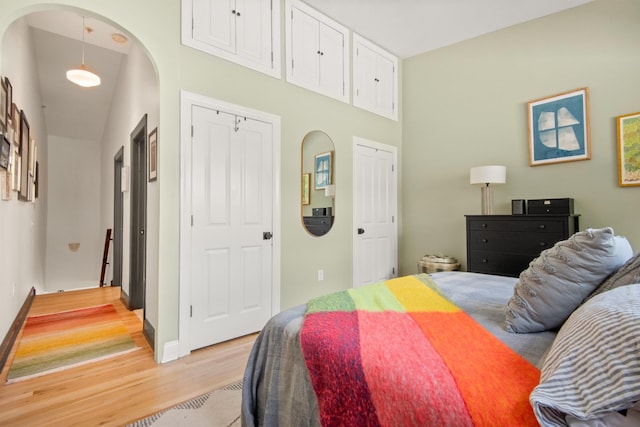 9 Coles St Unit 7, Jersey City, NJ 07302 - bedroom featuring arched walkways, light wood-style flooring, and multiple closets