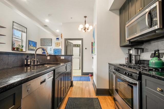 9 Coles St Unit 7, Jersey City, NJ 07302 - kitchen with stainless steel appliances, tasteful backsplash, light wood-style flooring, a chandelier, and dark stone counters