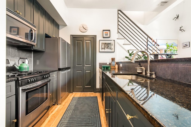 9 Coles St Unit 7, Jersey City, NJ 07302 - kitchen with stainless steel appliances, dark stone countertops, backsplash, and light wood-type flooring
