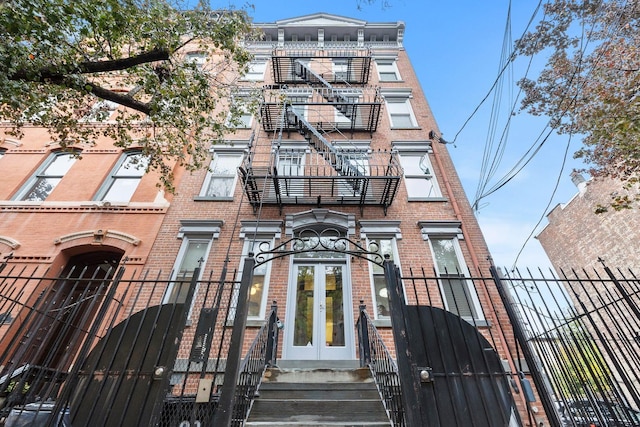 98 Bright St Unit 1G, Jersey City, NJ 07302 - view of front of home featuring french doors, brick siding, a gate, and a fenced front yard